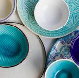 Mut zur Farbe  Es müssen nicht immer 12 Teller der gleichen Reihe sein – gleiches gilt für Gläser und Besteck! Freestyle ist absolut angesagt: Einfach mal in den Fundus der gesammelten Lieblingsteller (z.B. von Flohmärkten, oder Mitbringsel aus dem Urlaub, Einzelstücke aus der Boutique) greifen und für jeden Gast auf einem anders geformten und gefärbten Teller servieren. Das bringt nicht nur Farbe auf den Tisch sondern gleich auch Gesprächsstoff und Geschichten: Schließlich verbindet man gerade Einzelstücke gern mit besonderen Erinnerungen, die nur darauf warten, erzählt zu werden!