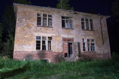 Scheinwerfer strahlen das Haus in Königsbrück, Sachsen, an, in dem sich der gesuchte mutmaßliche Mörder verschanzt hatte