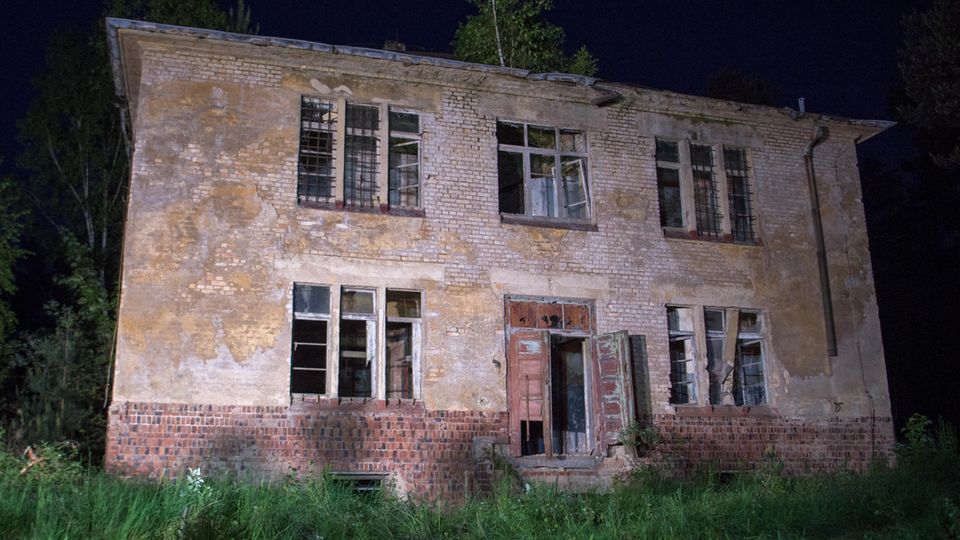Scheinwerfer strahlen das Haus in Königsbrück, Sachsen, an, in dem sich der gesuchte mutmaßliche Mörder verschanzt hatte
