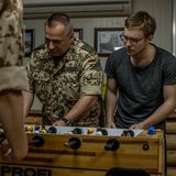 Soldaten und der Reporter spielen Tischfußball