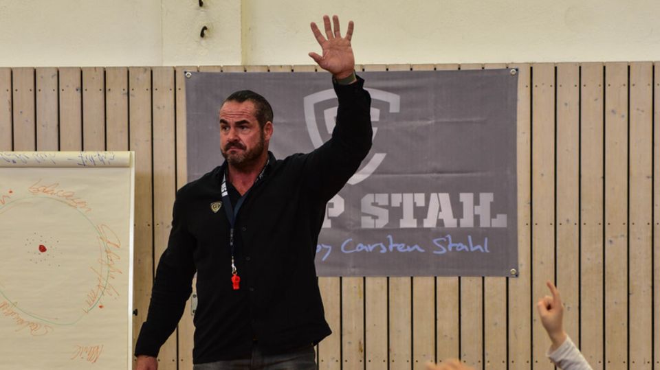 Carsten Stahl gibt unter anderem an Schulen zweitägige Seminare – das sogenannte Camp Stahl Carsten Stahl mit erhobenem Arm vor einer Gruppe Schüler, die auch den Arm heben