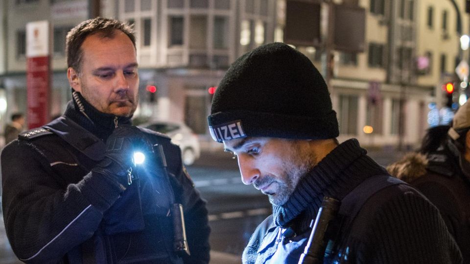Streifenpolizist Markus Knapp (l.) mit einem Kollegen in der Koblenzer Innenstadt. Über den Ohrstecker hört er den Funk. In dieser Nacht erreicht ihn die Meldung: "Überfall auf Spielhalle"