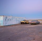 Im Doppelpack neben einem 40-Fuß-Container in der Mojave-Wüste in Kalifornien: ein 1956er Chevrolet Belair ohne Scheiben und eine Chevrolet Impala mit Schlagseite aus dem Jahre 1969.