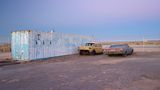 Im Doppelpack neben einem 40-Fuß-Container in der Mojave-Wüste in Kalifornien: ein 1956er Chevrolet Belair ohne Scheiben und eine Chevrolet Impala mit Schlagseite aus dem Jahre 1969.