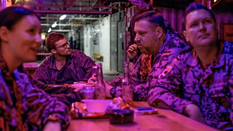 Bundeswehrsoldaten und Reporter Frederik Seeler sitzen an einem Tisch und trinken Bier