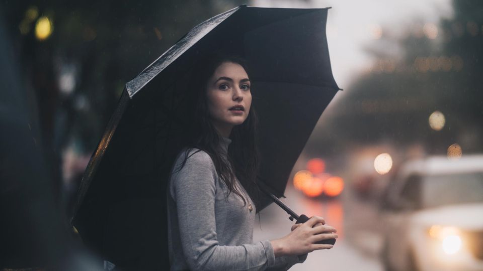 Frau mit Regenschirm auf Straße