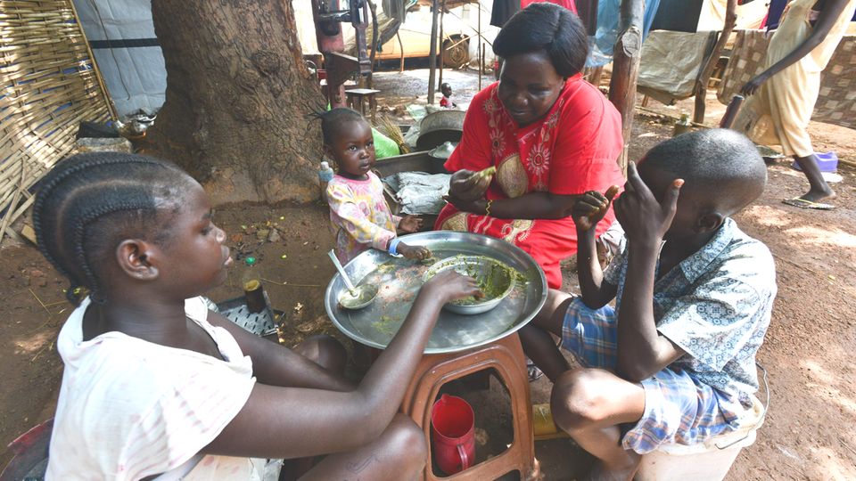 Eine Familie isst in einer Flüchtlingsunterkunft in Wau im Südsudan gemeinsam zu Mittag Eine Familie isst in einer Flüchtlingsunterkunft in Wau im Südsudan gemeinsam zu Mittag