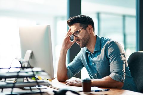 Genervter Mann vor Computer im Büro