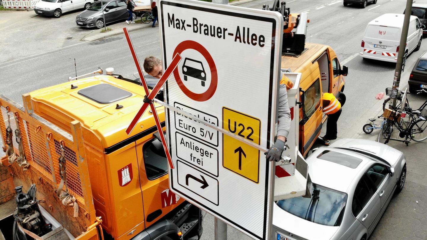 Handwerker bauen ein Schild auf, welches auf das Diesel-Fahrverbot in Hamburg verweist