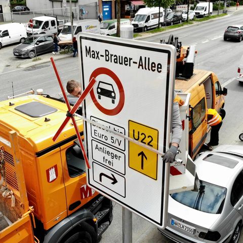 Handwerker bauen ein Schild auf, welches auf das Diesel-Fahrverbot in Hamburg verweist