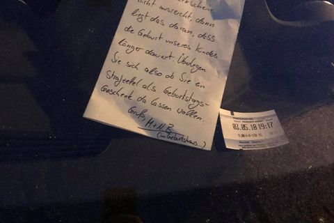 Ein handgeschriebener Brief liegt in der Windschutzscheibe eines Autos