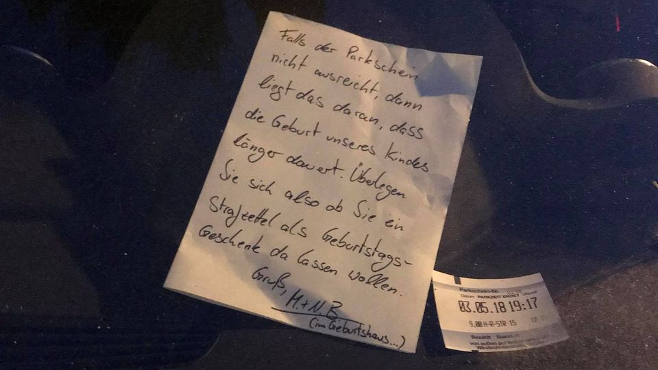 Ein handgeschriebener Brief liegt in der Windschutzscheibe eines Autos