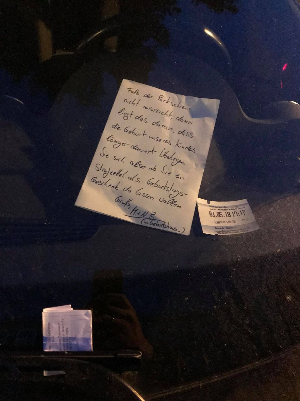 Ein von handgeschriebener Brief liegt in der Windschutzscheibe eines Autos