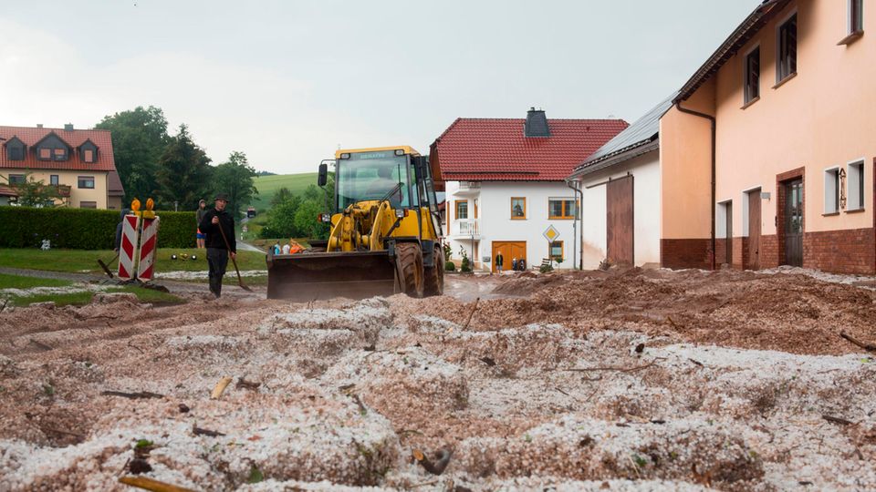 Hessen, Hetzerode: Nach Starkregen und Hagelschlag wird eine blockierte Straße geräumt