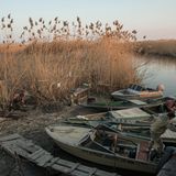 Das Wasser der Wolga ist so seicht, dass die Männer in schmalen Kähnen durch das Wasser gleiten müssen.