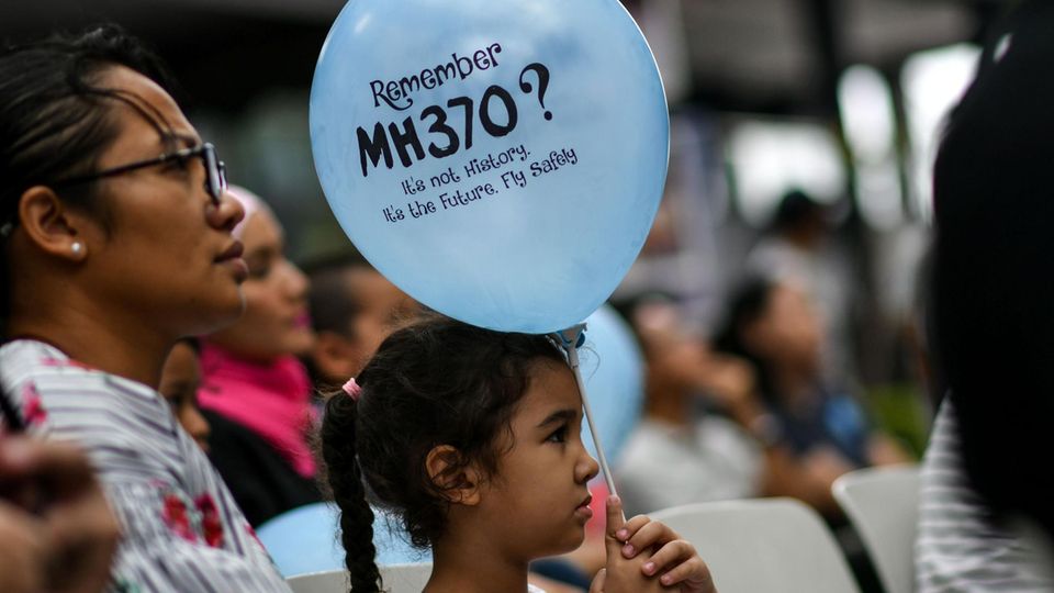 Mädchen hält Luftballon in Gedenken an verschollenen Flug MH370
