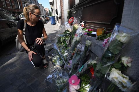 Eine Frau kauert an einer improvisierten Gedenkstätte für die Opfer des Attentäters von Lüttich