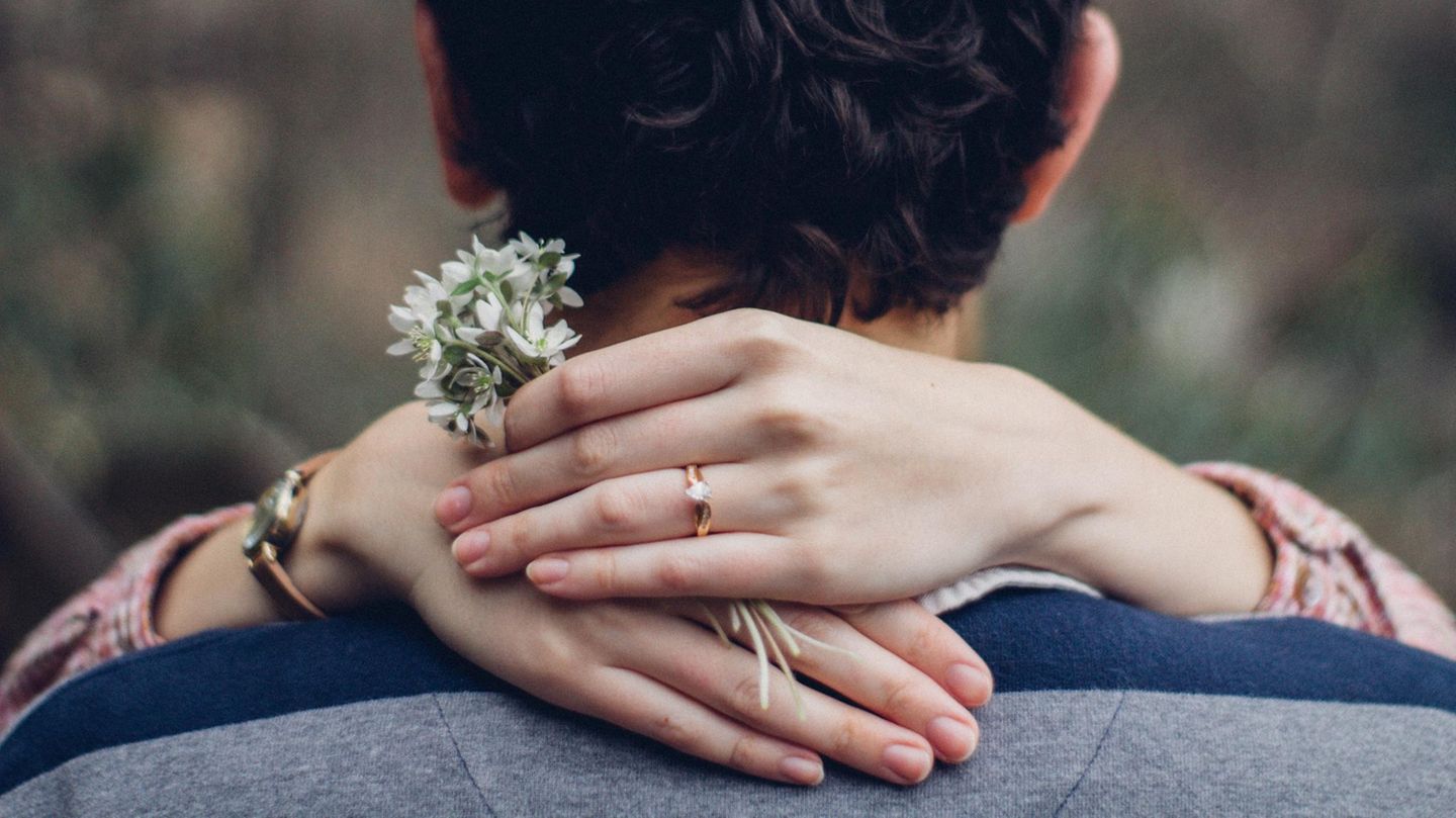 Hochzeit: Ein Pärchen umarmt sich, an der Hand der Frau sieht man einen Ring