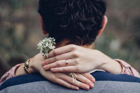 Hochzeit: Ein Pärchen umarmt sich, an der Hand der Frau sieht man einen Ring