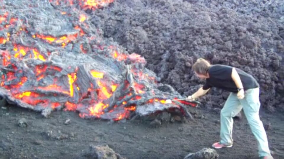 Ein Mann röstet einen Marshmallow über Vulkanlava