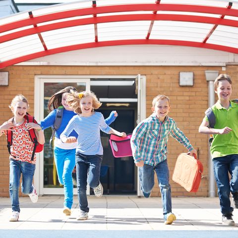 Hitzefrei: Junge Schüler rennen freudig aus der Schule