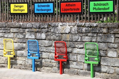 bunte Stühle mit Ortsschildern