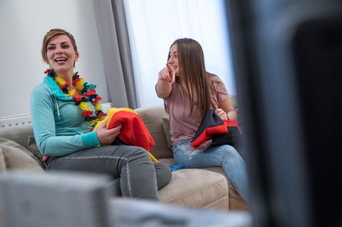 Zwei junge Frauen schauen zusammen Fußball im Fernsehen