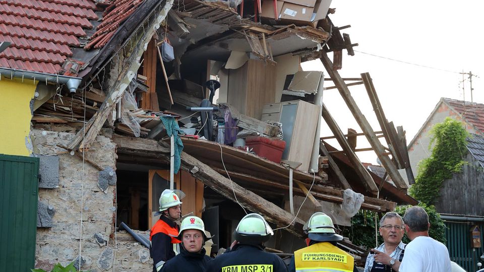 Nachrichten Deutschland Himmelstadt Feuerwehrleute stehen in Himmelstadt vor einem nach einer Verpuffung eingestürzten Wohnhaus