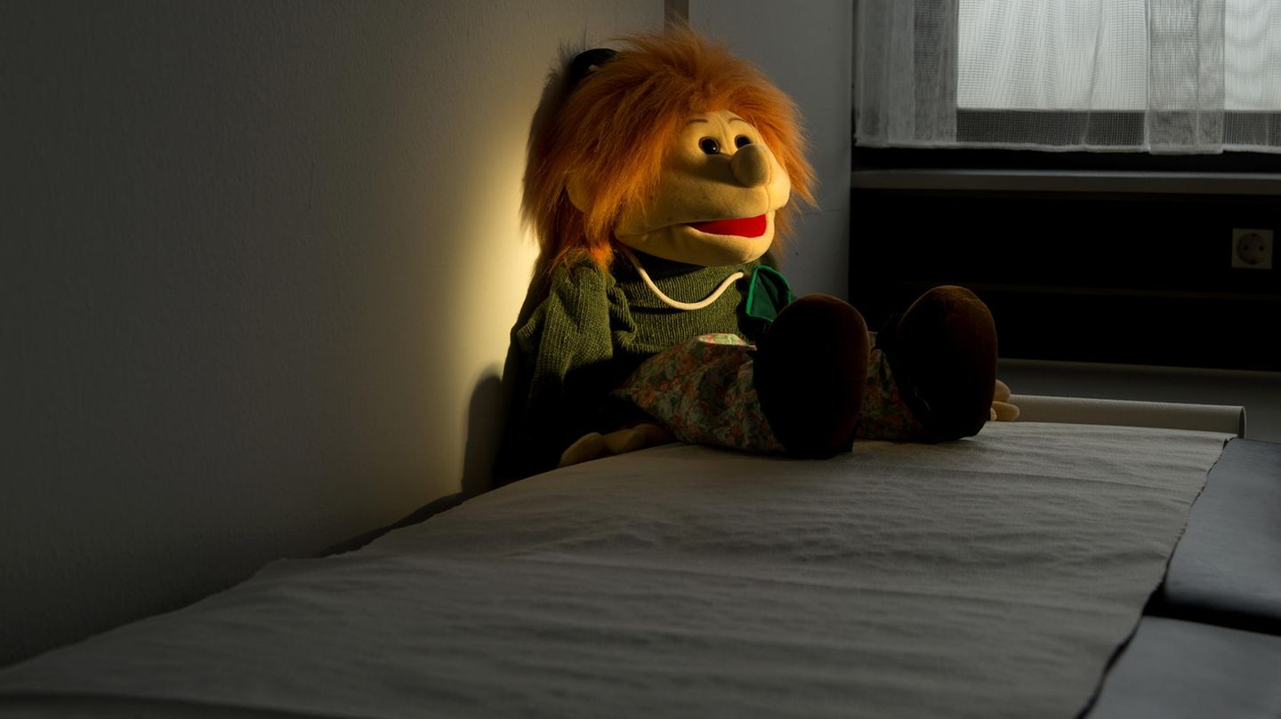Ein Stofftier liegt im Dunkeln auf einem Bett