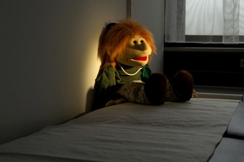 Ein Stofftier liegt im Dunkeln auf einem Bett