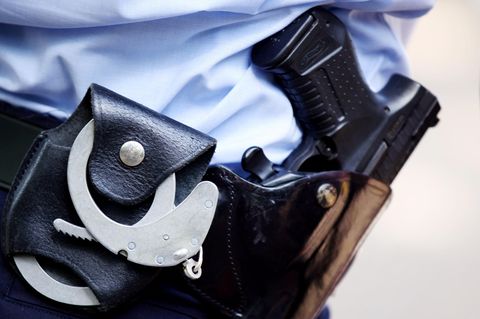 Ein Polizist mit Handschellen und Pistole am Gürtel in Köln
