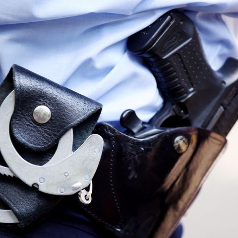 Ein Polizist mit Handschellen und Pistole am Gürtel in Köln