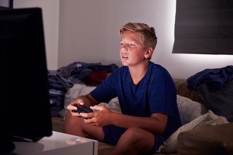 Ein Junge sitzt vor einem Bildschirm und spielt Computerspiele