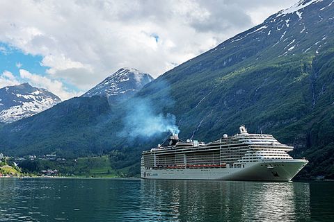 Ein Kreuzfahrtschiff mit Abgasfahne im Geirangerfjord