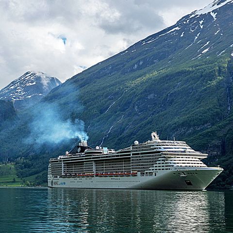 Ein Kreuzfahrtschiff mit Abgasfahne im Geirangerfjord