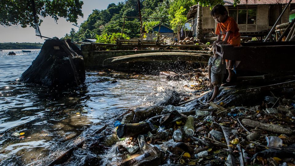 Der verdreckte Strand von Banda Neira, mittendrin spielende Kinder