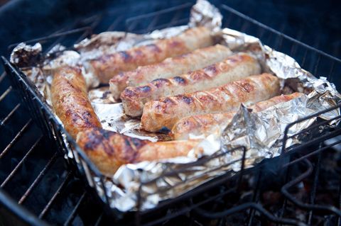 Würstchen mit Alufolie liegen auf dem Grill