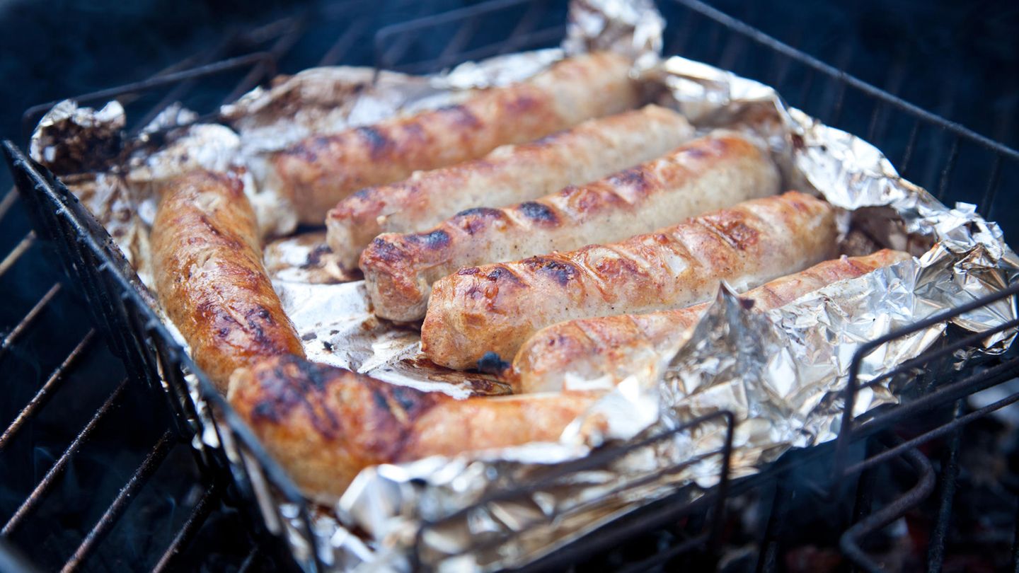 Würstchen mit Alufolie liegen auf dem Grill