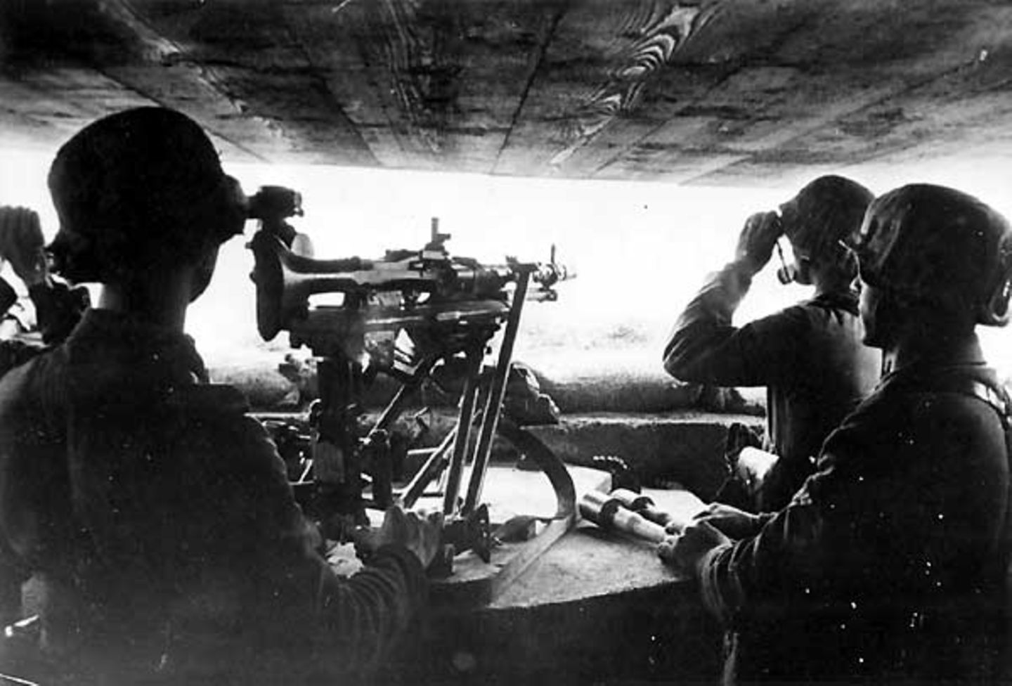 Bunte Truppe  Soldaten einer MG-Stellung in einem Bunker des Atlantikwalls halten Ausschau aufs Meer. Mit solchen Bildern wurde der Atlantikwall in deutschen Wochenschauen gefeiert. Doch die Truppen waren zusammengewürfelt aus Landsern, die nach einer Verwundung ins "erholsame" Frankreich versetzt worden waren, und Soldaten aus den besetzten Staaten Europas, die mehr oder weniger freiwillig in den Reihen der Wehrmacht kämpften