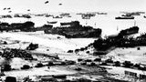 Provisorischer Hafen  Hunderte Schiffe liegen vor der Küste der Normandie. An den breiten Sandstränden entladen landungsboote ihre Fracht. Lastwagen formieren sich zu Marschkolonnen. Über der Szene schweben Fesselballons, die mit ihren Stahltrossen deutschen Fliegern den Weg versperren und so Angriffe verhindern sollen