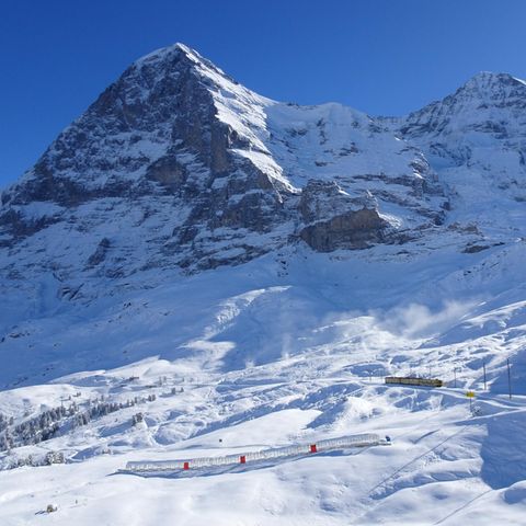 Die Jungfraubahn am Fuße der verschneiten Eiger Nordwand.