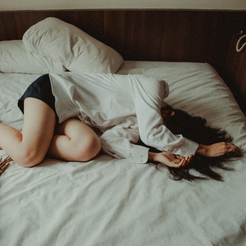 Junge Frau liegt im Bett