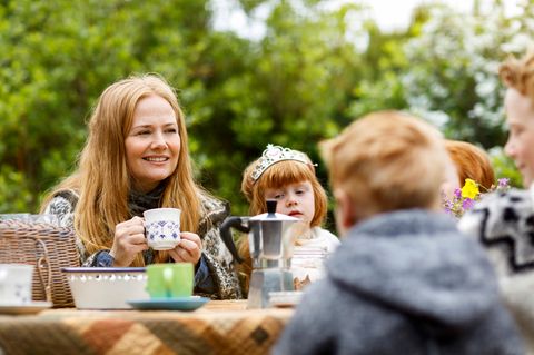 Eine Mutter sitzt mit vier Kindern am Tisch