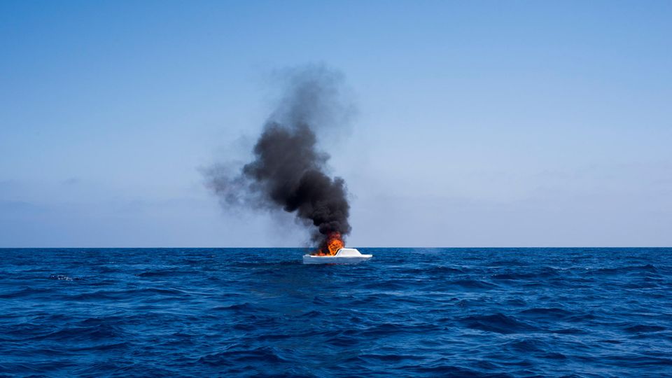Nachdem die Flüchtlinge in Sicherheit gebracht wurden, brennen die Helfer die Boote ab – damit sie nicht wieder in die Hände von Schleusern fallen