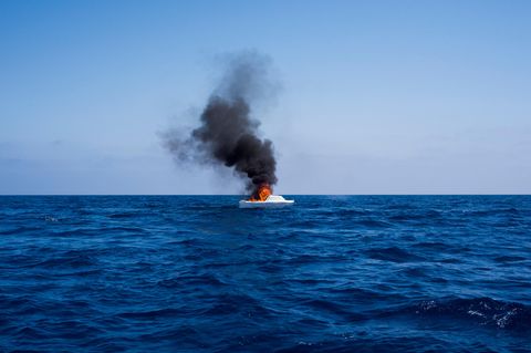 Nachdem die Flüchtlinge in Sicherheit gebracht wurden, brennen die Helfer die Boote ab – damit sie nicht wieder in die Hände von Schleusern fallen