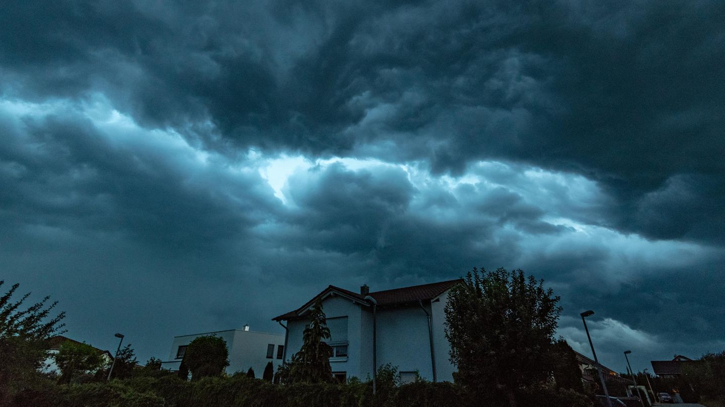 Unwetter heute: Dunkle Gewitterwolken ziehen am Montagabend über ein Wohngebiet in Straubing, Bayern.