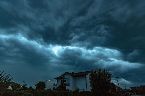 Unwetter heute: Dunkle Gewitterwolken ziehen am Montagabend über ein Wohngebiet in Straubing, Bayern.