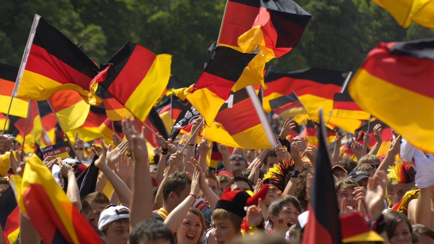 Menschen mit Deutschland-Fahnen jubeln beim Public Viewing