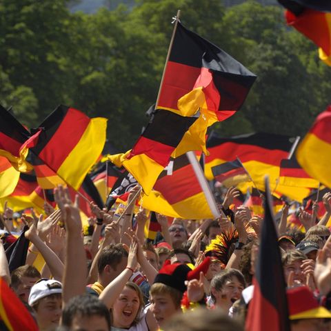 Menschen mit Deutschland-Fahnen jubeln beim Public Viewing