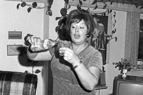 Eine Frau trinkt einen klaren Schnaps